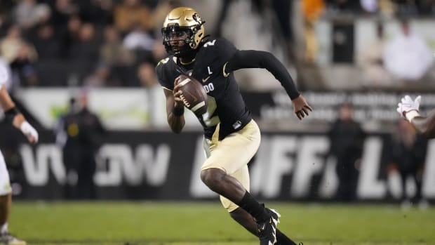 Colorado Buffaloes quarterback Shedeur Sanders scrambles with the football.